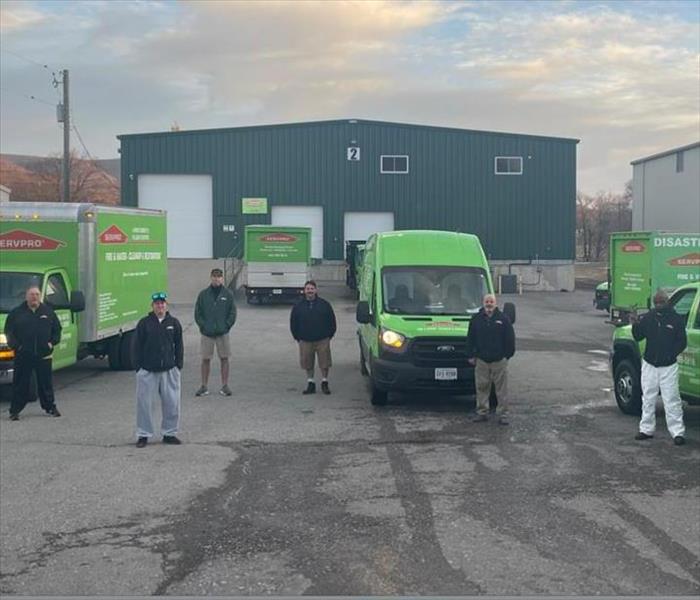 Group of men standing in front of SERVPRO cars